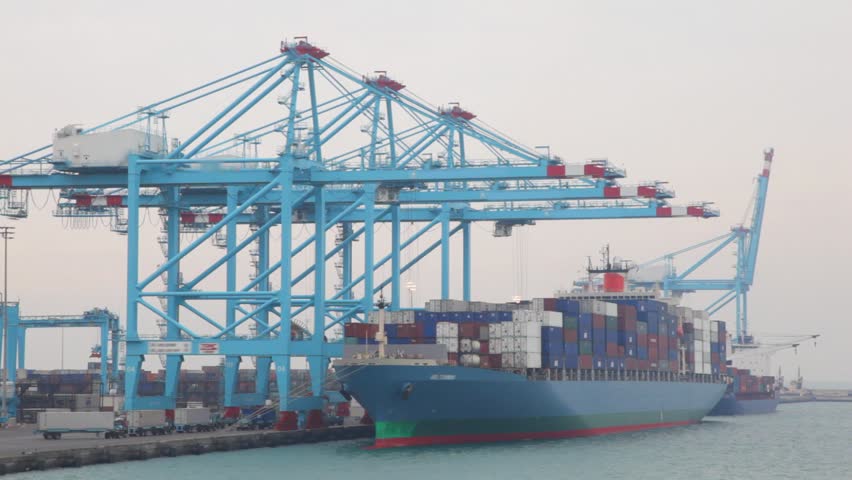 barge with containers stopped in seaport during unloading