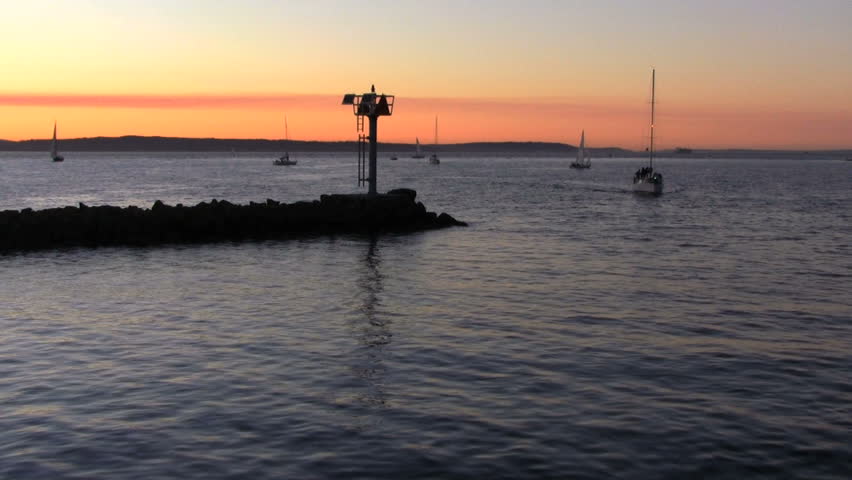 Time lapse. Boats enter inlet at sunset