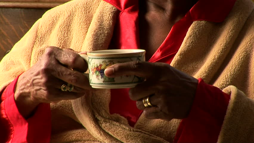 Close up of senior woman drinking tea by bedroom window