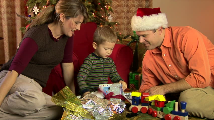 Mother, father and son in pajamas opening Christmas presents