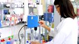 Chemist At Work. 
A young chemist working in a laboratory. She works with lab mixer and mixing chemicals in an experiment.