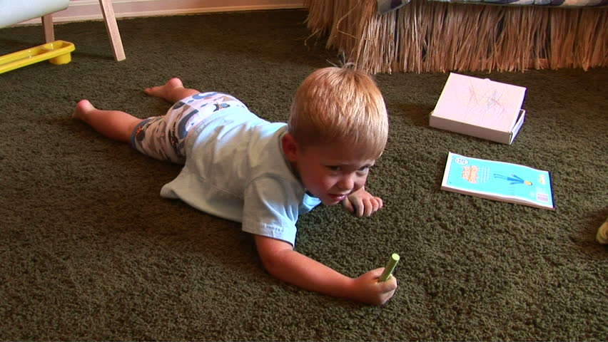 Young two year old writing with chalk on board