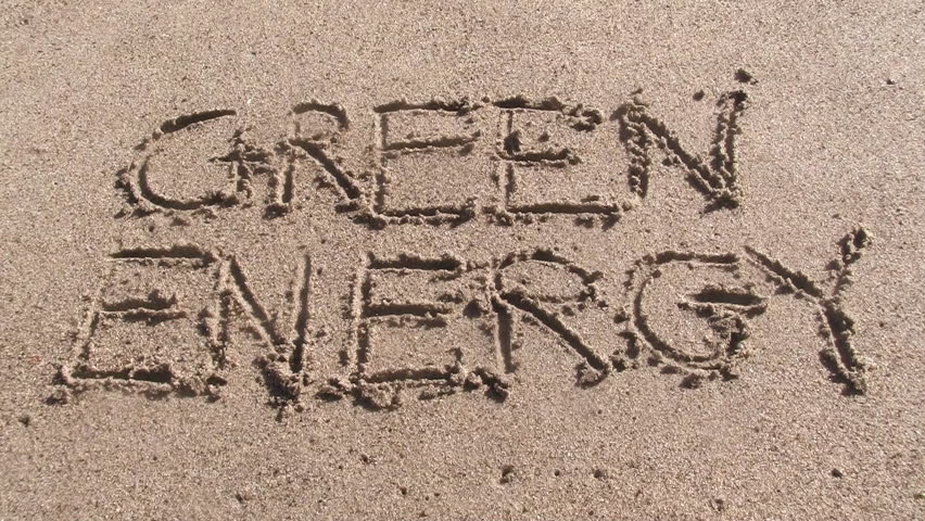 GREEN ENERGY written in sand gently wiped off by wave 