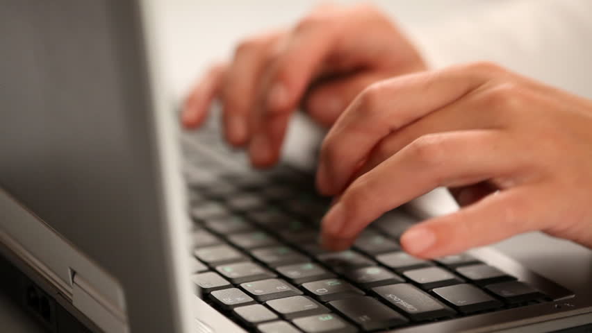 Hands typing on a laptop keyboard