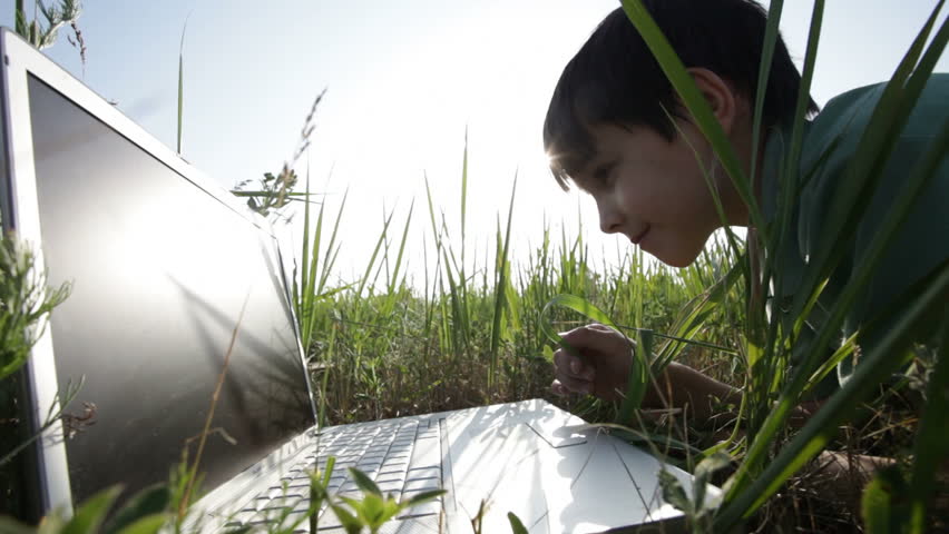 boy and  laptop.  nature. Summer.  green grass