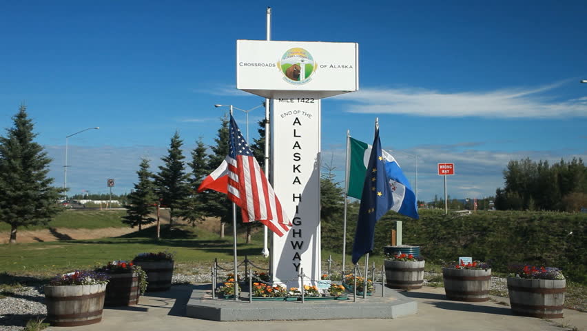 Historical end of the ALCAN Alaskan highway from Dawson Creek to Delta Junction. End of military built road from world war II in defense against Japanese attack. Flags and memorial.