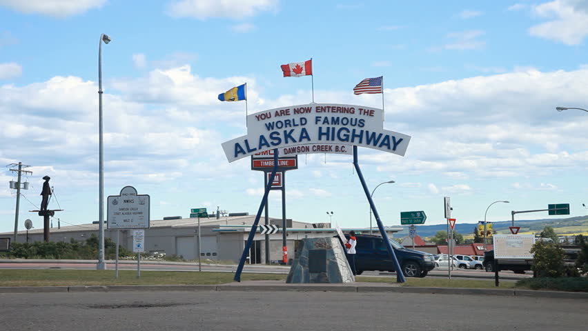 Dawson Creek, British Columbia, sign starting the famous ALCAN Alaskan Highway. Traffic driving by.