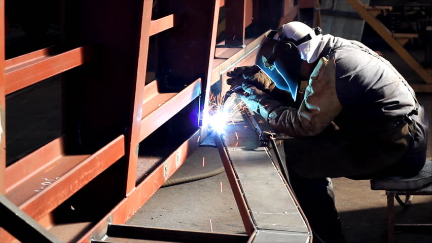 Welder at work in factory