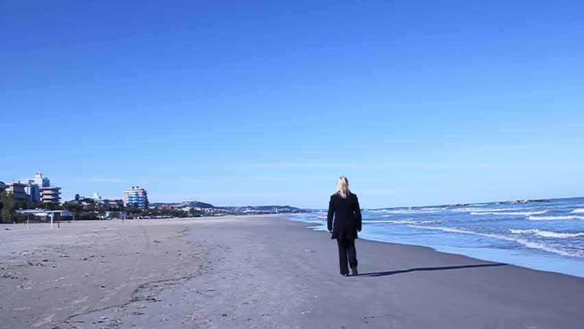 Middle-aged woman walks along the sea