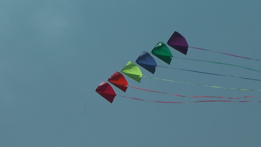 Colorful kite soaring against blue sky. Summer Kite Festival