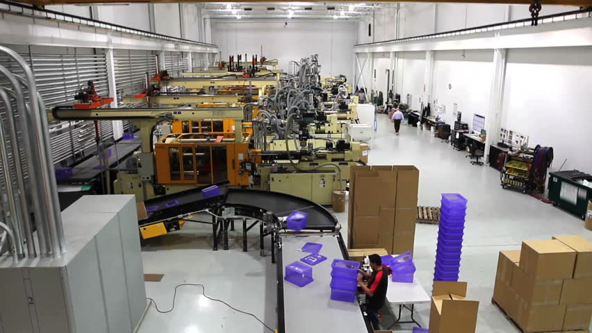 A wide shot time lapse of an entire robotics assembly plant in motion. 