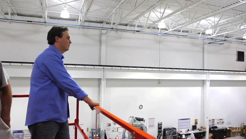 A supervisor overlooks production of a large robotics factory 