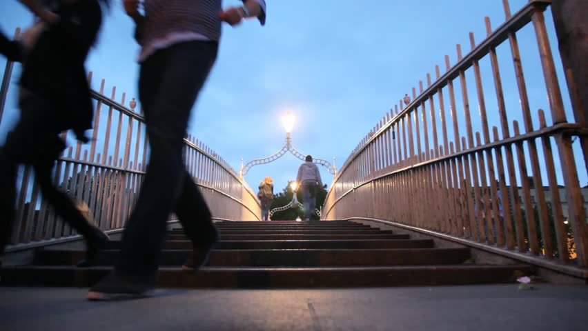 Back view of people walking on The Ha'penny Bridge in Dublin, Ireland