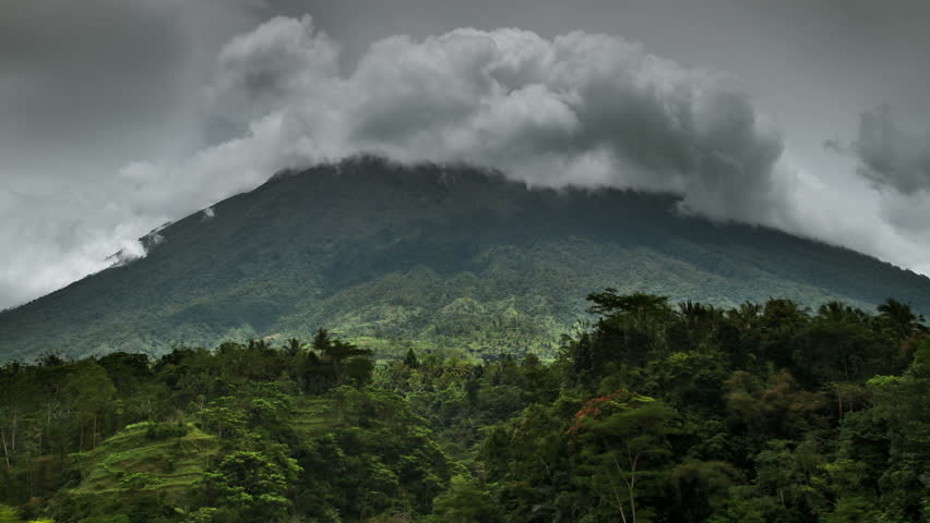 Mount in jungle and time lapse clouds around volcano. 25 fps