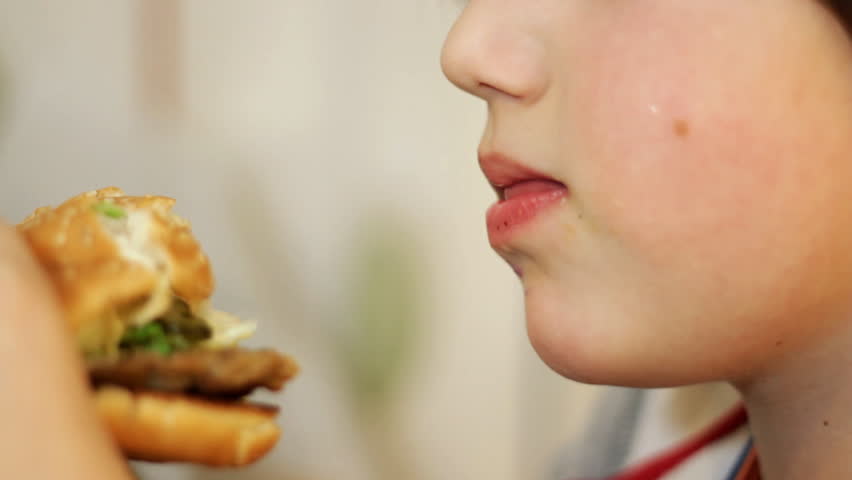 Closeup of children mouth eating hamburger 