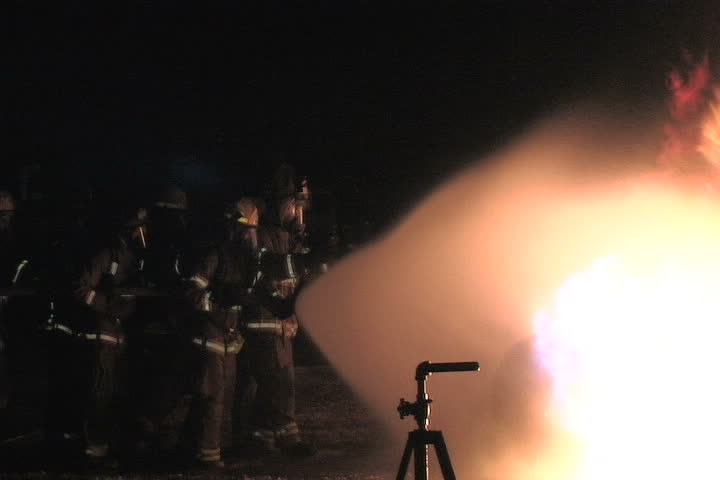 Side view of firefighters battling a liquid propane tank fire