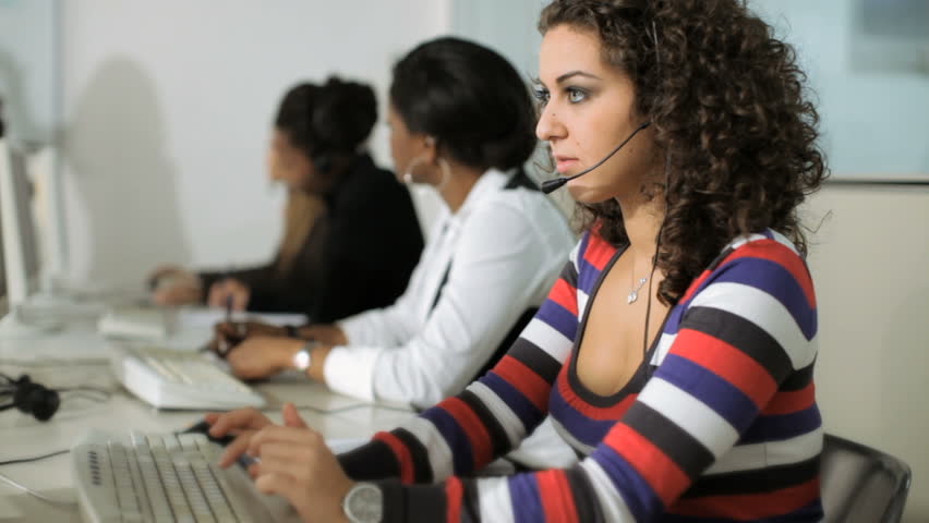 Multiethnic group of female customer service representatives in a meeting with businesswoman talking 