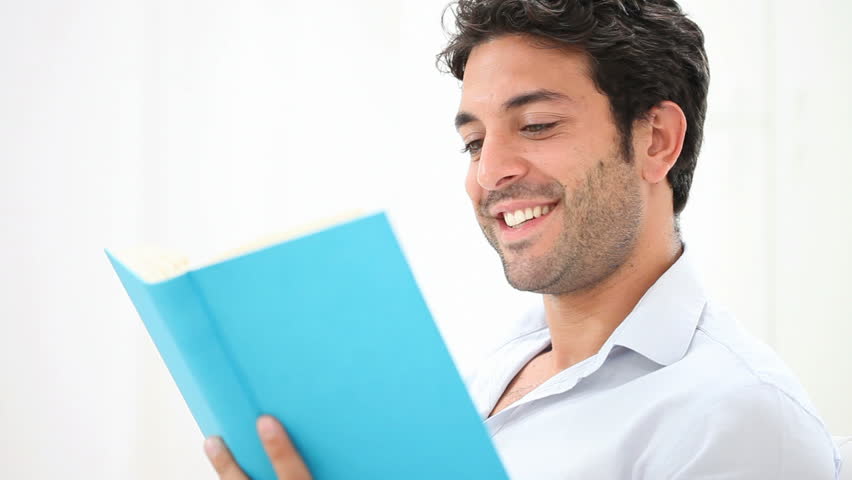 Stock Video Of Smiling Young Man Reading A Novel