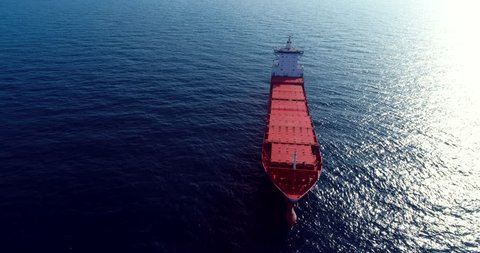 367 Aerial 4k cinematic with a Large red Bulk ship . Orbiting a coal ship out on the open sea