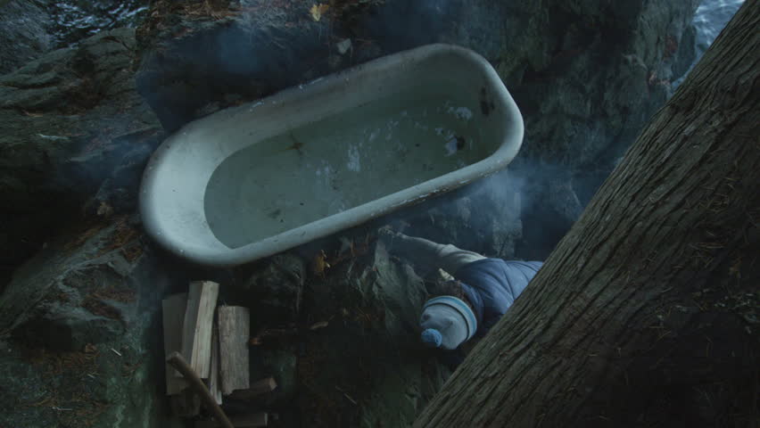 Man In Outdoor Bathtub Heated By Fire