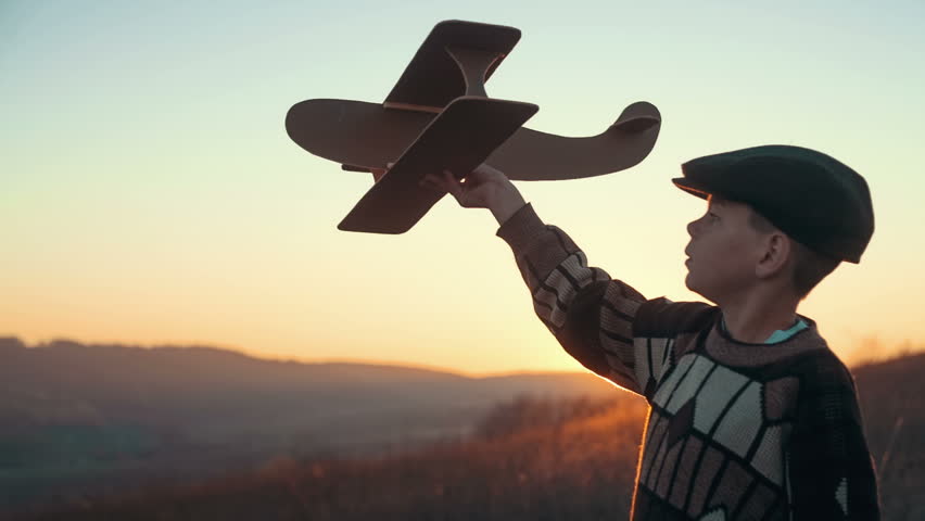 Happy Kid Playing With Toy Airplane Against Orange Sun Summer Sky ...