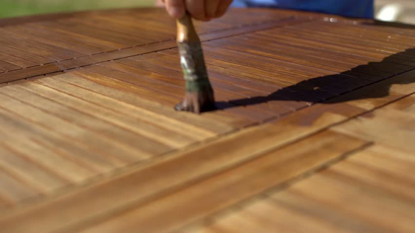 closeup shot of restorer restoring a wooden table varnishing with a mordant garden furniture - Garden Furniture Varnish closeup shot of restorer restoring a wooden table varnishing with a mordant garden furniture - Garden Furniture Varnish