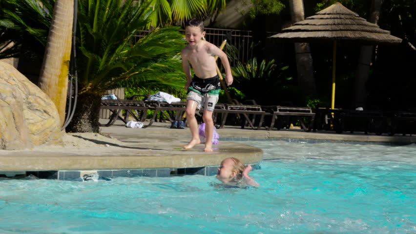 Young Boy Jumps Into Swimming Pool And Makes A Big Splash In