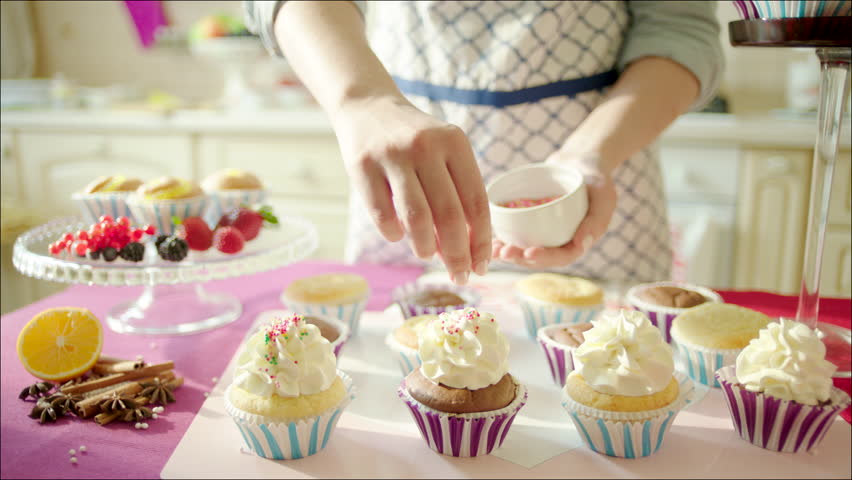 Woman Decorating Cupcakes girl cook in the kitchen, prepares chocolate cupcakes. stock Woman Decorating Cupcakes girl cook in the kitchen, prepares chocolate cupcakes. stock