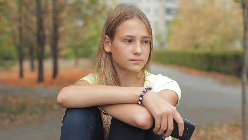 Sad Girl Depressed Cute Teen Female Sitting Deep In Thought With Head On Knees On Park Bench