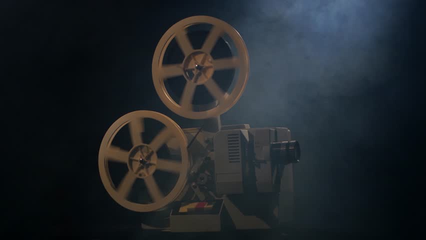 Old Projector Showing Film In The Smoke. Studio Black Background Stock 