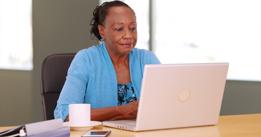 A Portrait Of An Older Black Woman Celebrating While Using Her Computer ...