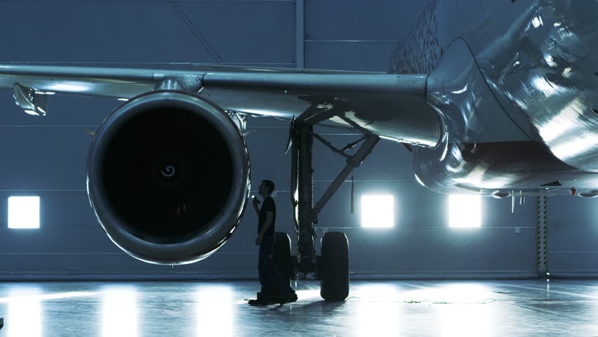 Aircraft Maintenance Mechanic Inspects And Tunes Plane Engine In A ...