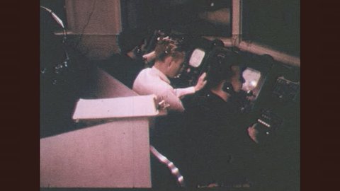 1950s Men In Television Station Control Room Operate Dials Monitor Screens Men Stand At A Height Operating Microphone And Television Cameras Lighting