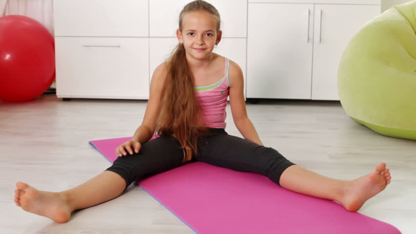 Young Girl Exercising At Home Doing Stretching Gymnastic Exercises 