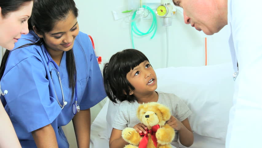 Male Pediatric Physician Cheering Up A Young Female Patient With A ...