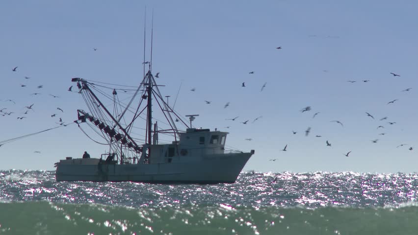 A commercial fishing boat on the horizon in the distance.  In 4K UltraHD.