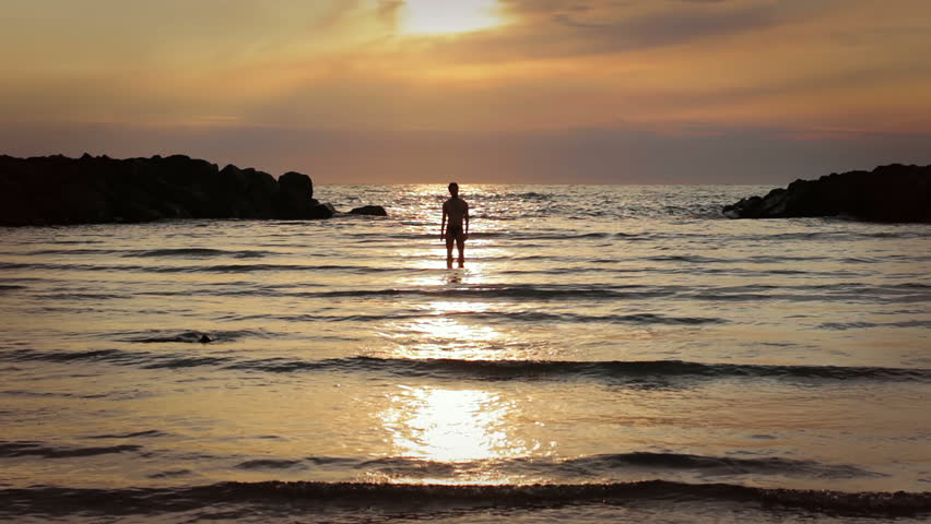 A Boy And Girl Into The Sea At Sunset Chases And Jokes With Water Stock ...