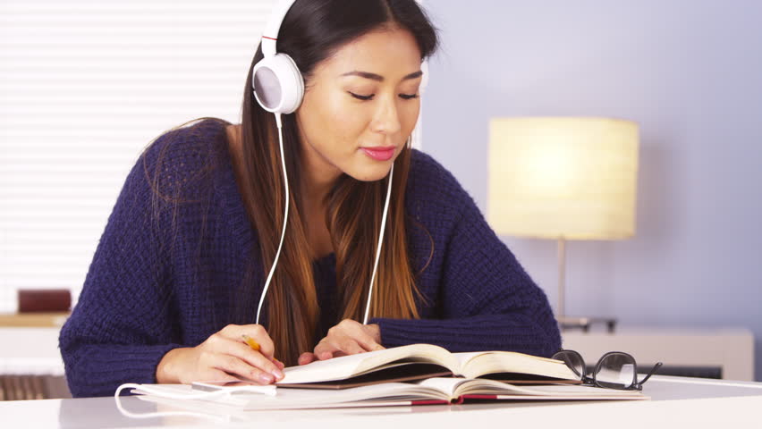 Chinese Woman Listening To Music While Doing Homework Stock Footage Video 6819847 Shutterstock