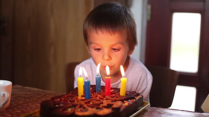 A Little Girl Blows Out Candles On A Birthday Cake In Slow Motion ...