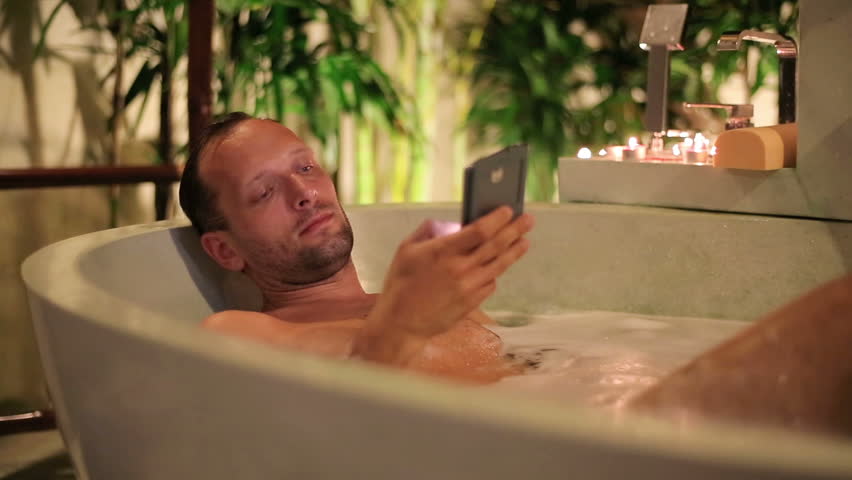 Man Texting Sms On Smartphone Sitting In The Bathtub Stock Footage Man Texting On Smartphone While Lying In Bathtub Bathroom Hd Stock Footage Clip