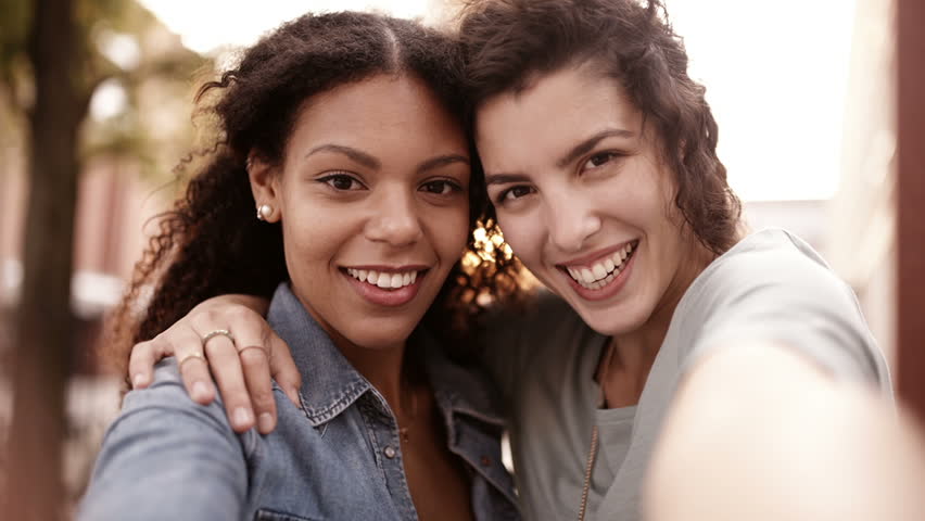 Mixed Race Girl Friends Walking In City Urban Area With Shopping Bags ...