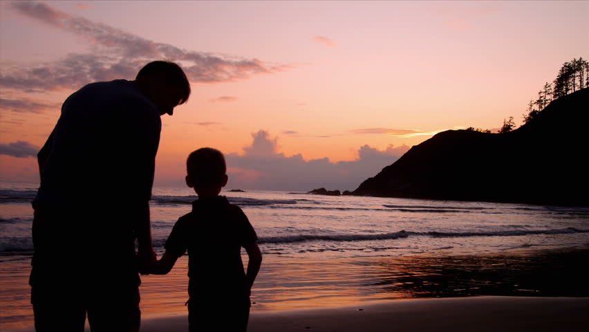 Two Friends High Five Each Other Looking Out At Sunset From Beach Stock ...